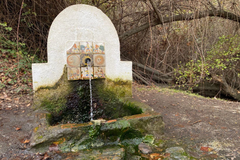 La fuente conocida como fuente gaseosa a las afueras del pueblo de Ferreirola emanando su agua ferruguinosa